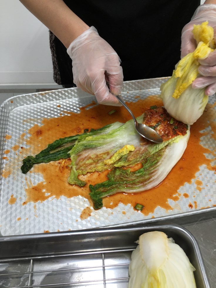 Spread the yangnyeom in between the leaves of the Chinese cabbage